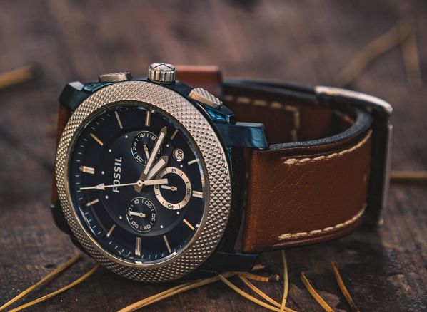 A moonphase watch with brown leather wristband.