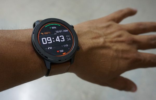 A digital watch worn by a hand.