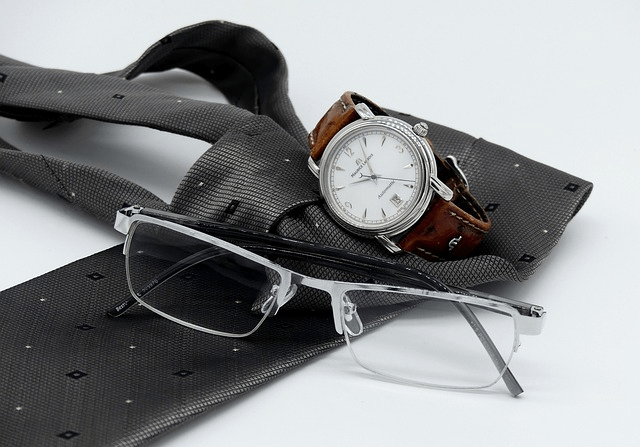 luxury watch with brown strap and glasses