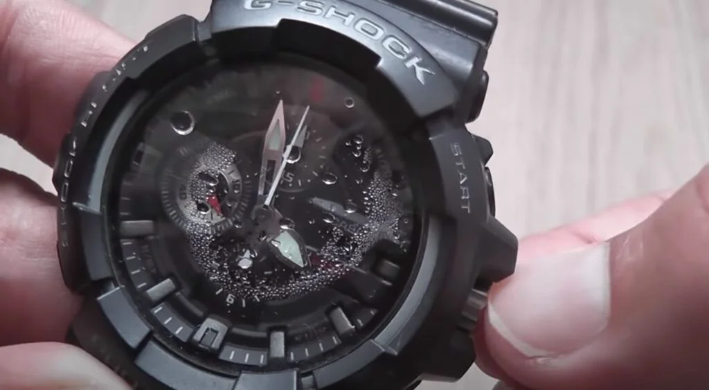 water condensation droplets inside watch hand holding it removing water